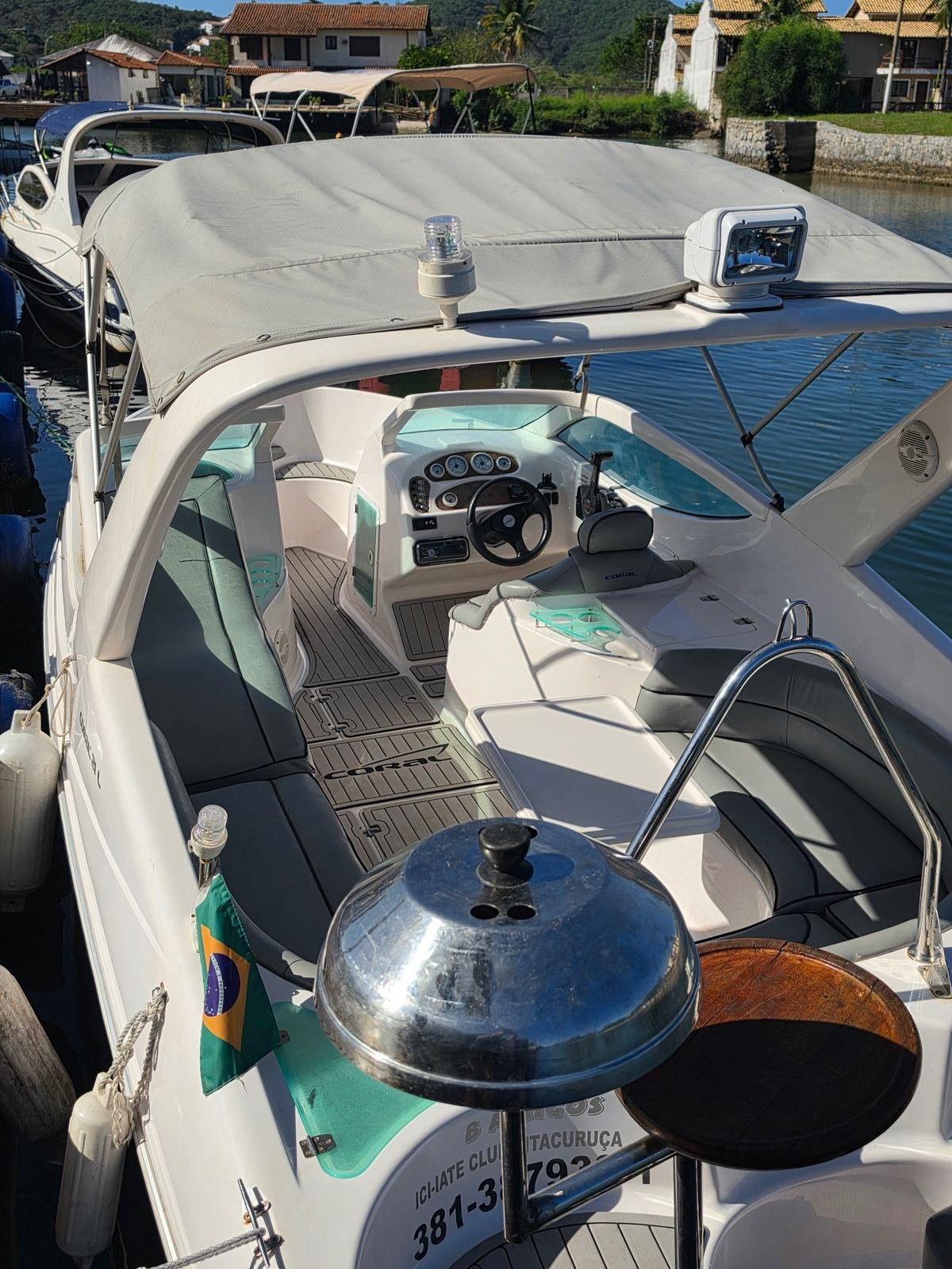 Cockpit da lancha com o leme e a churrasqueira na popa